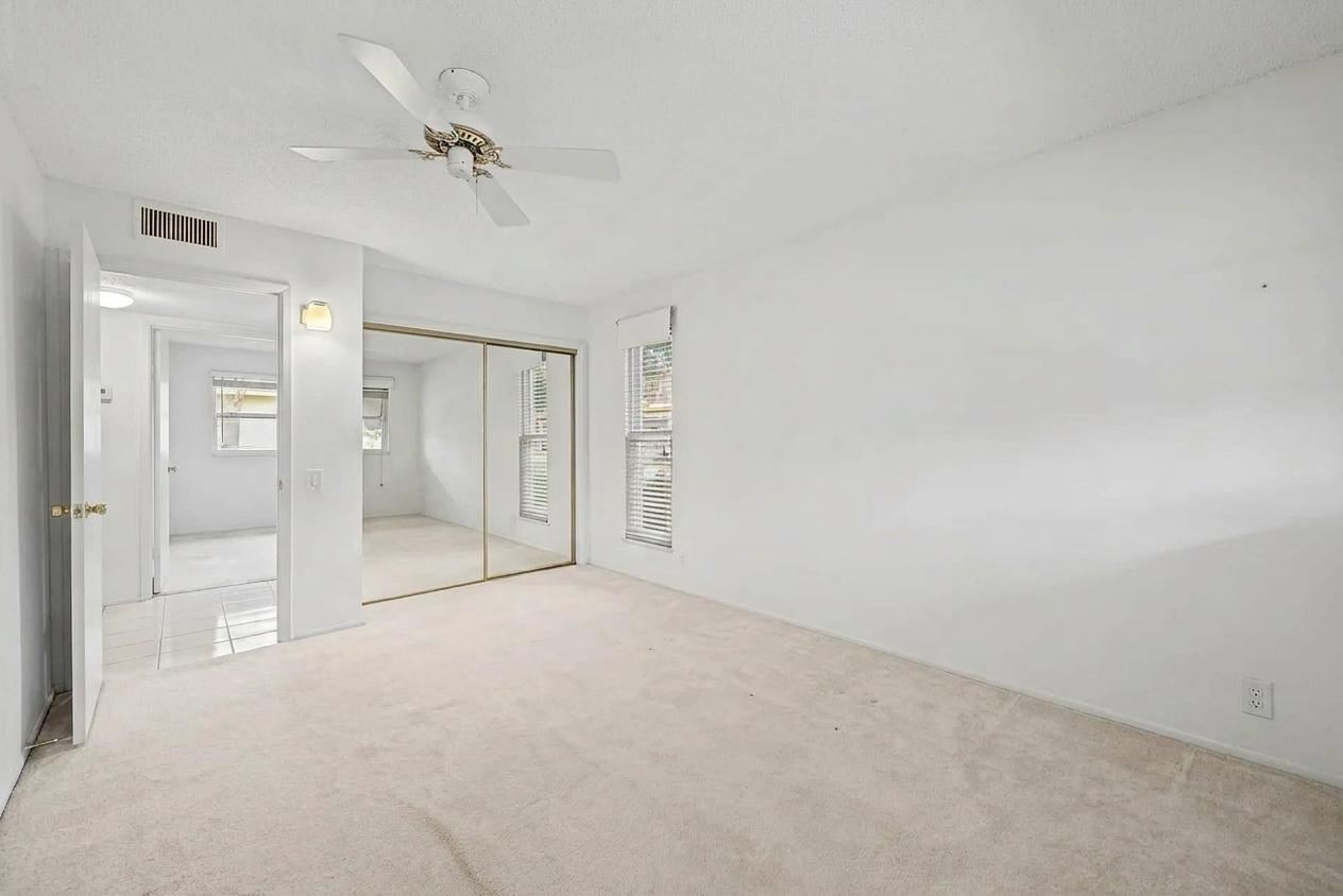Primary bedroom with mirrored closet and ensuite doorway