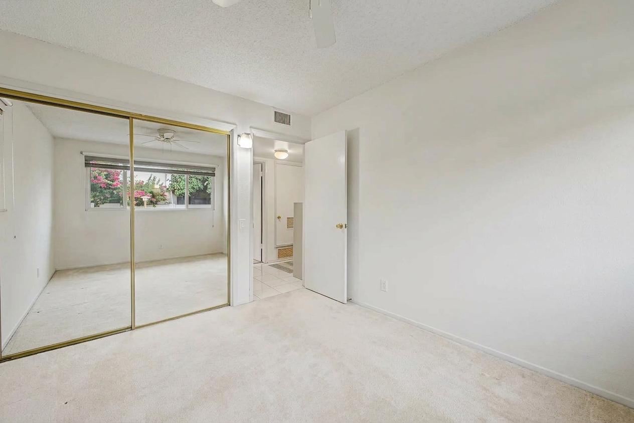 Bedroom with mirrored closet, garden window and bathroom access