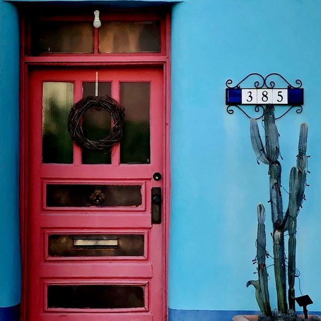 Pink door and cactus on a blue wall in Cave Creek, Arizona