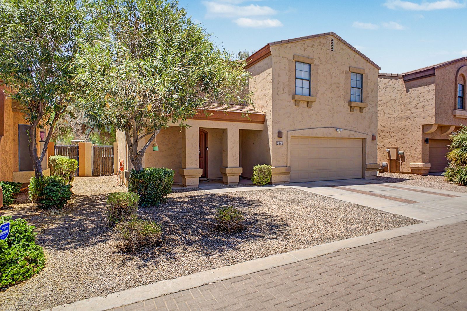 Front exterior with mature shade trees and low-water landscaping