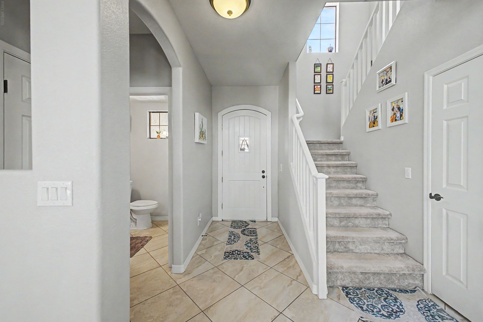 Entry foyer with staircase and downstairs powder room
