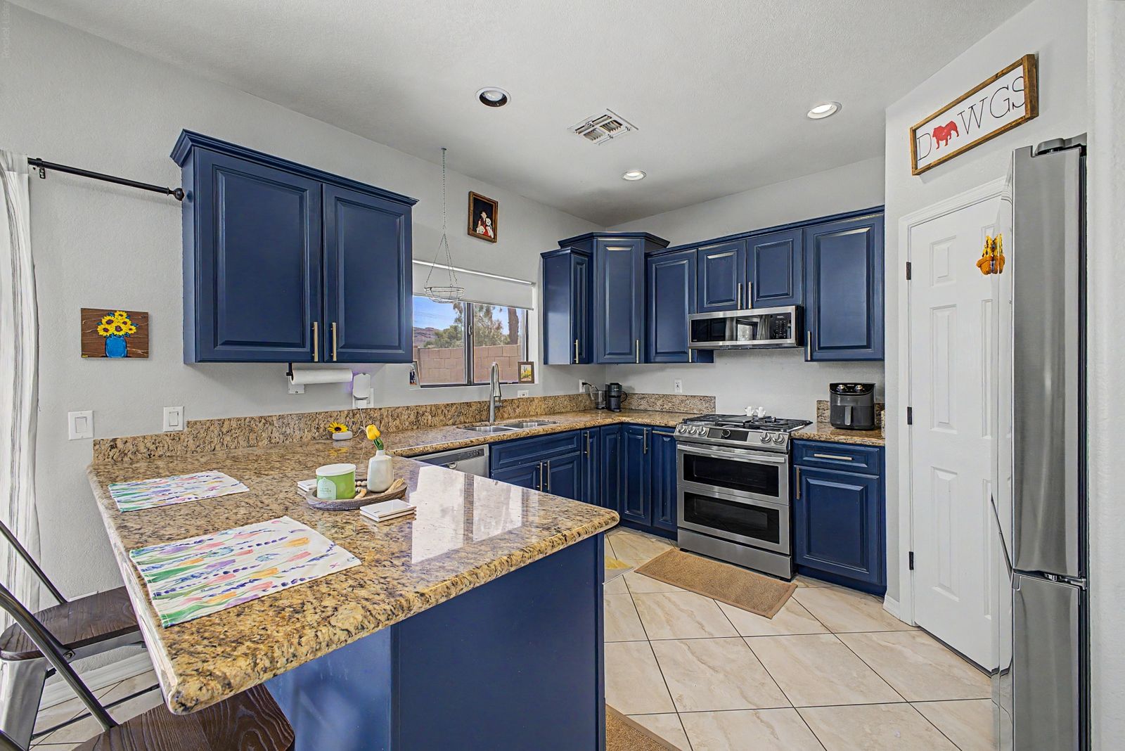 Kitchen peninsula with navy cabinets and gas range