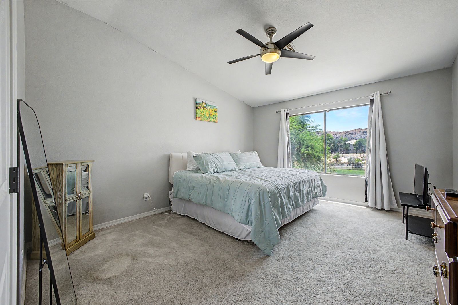Primary bedroom with ceiling fan and large window
