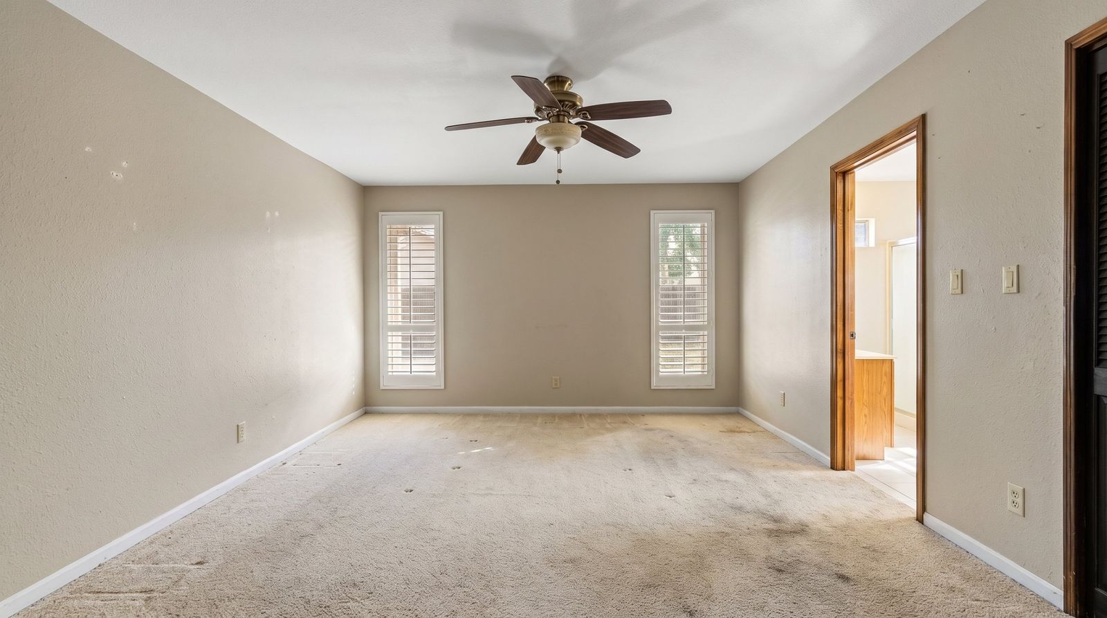Primary bedroom with two shuttered windows